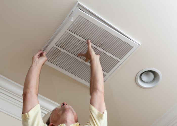 HVAC professional checking air ducts during cleaning in The Woodlands